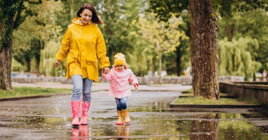 Klimaschutz zu Fuß: Mutter mit Kind läuft durch einen Park.