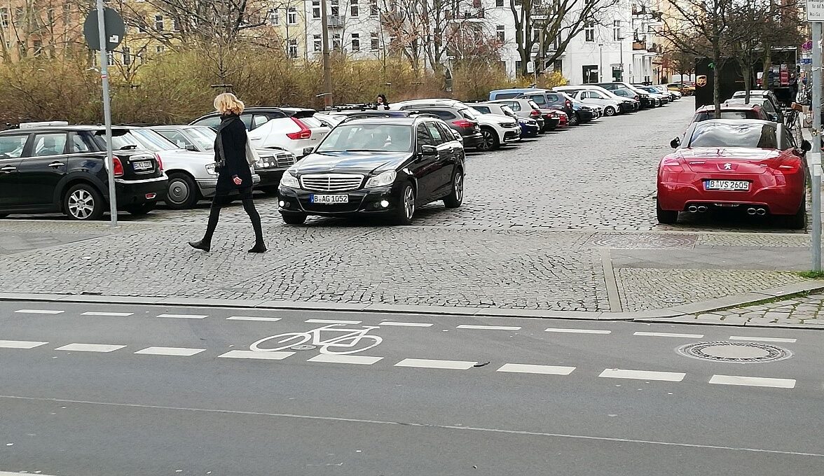 Fußgängerin überquert Straße über eine Aufpflasterung