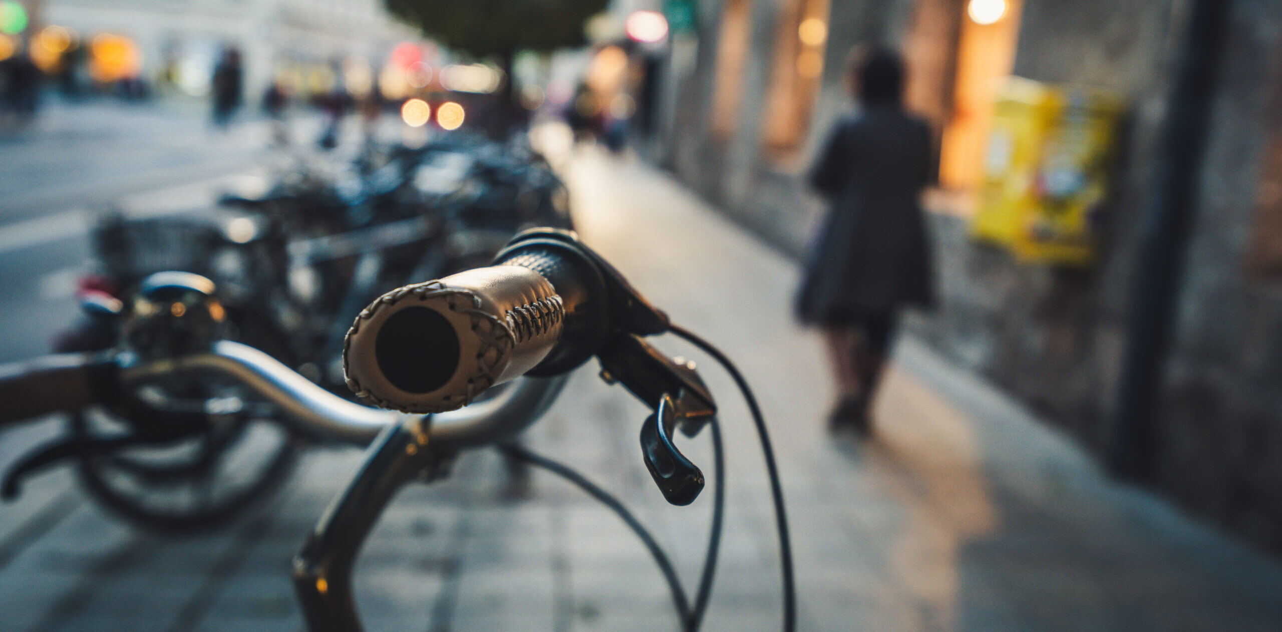 Fahrradlenker, im Hintergrund ein Gehweg.