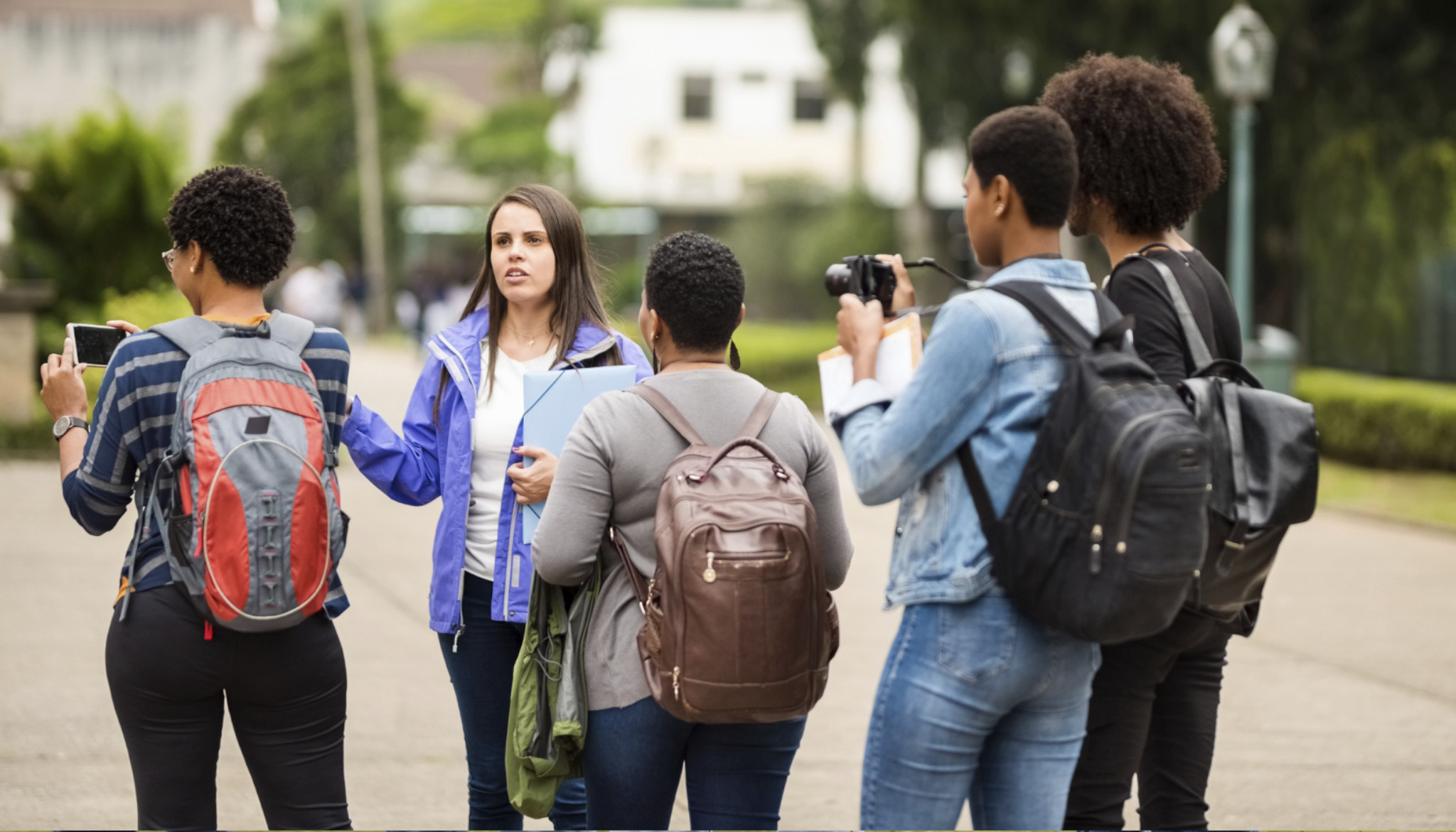 Eine Gruppe Menschen mit Fotoapparaten und Klemmbrettern steht auf einer öffentlichen Straße